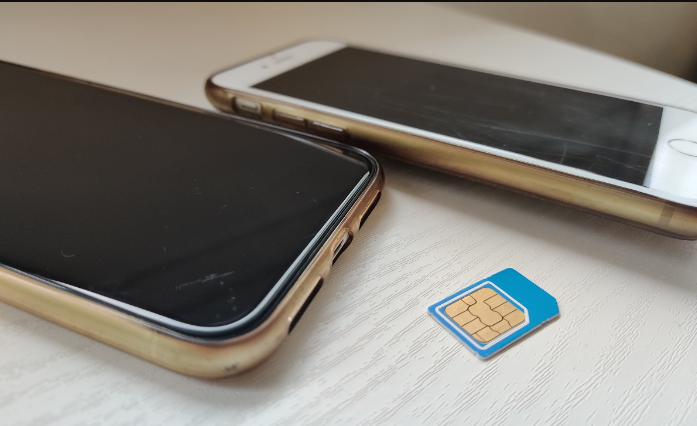 Kuvassa on SIM-kortti ja 2 älypuhelinta