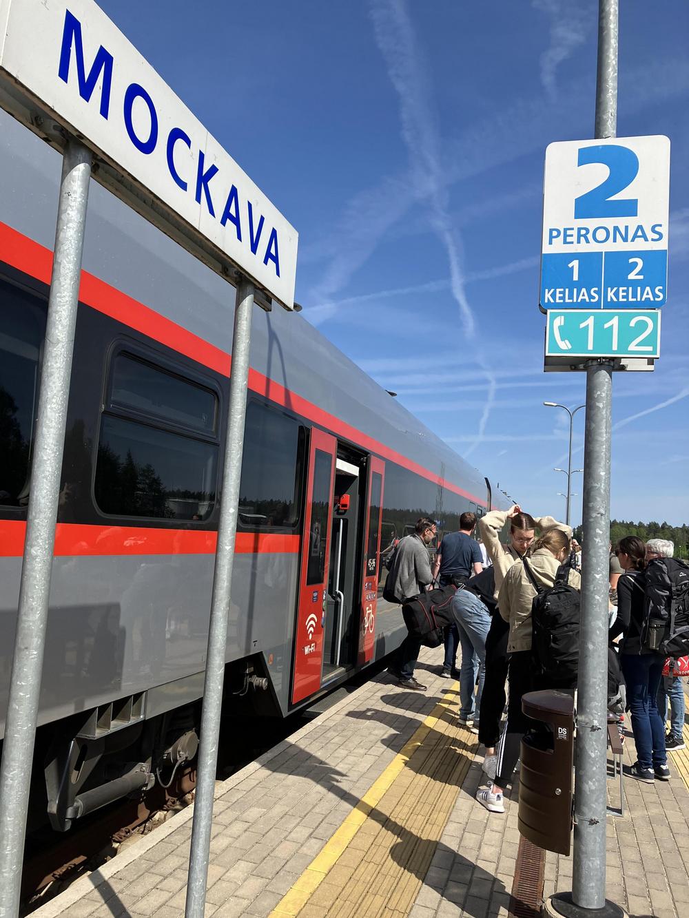 Kuva junanlaiturilta: juna, ihmisiä ja raiteen numero.