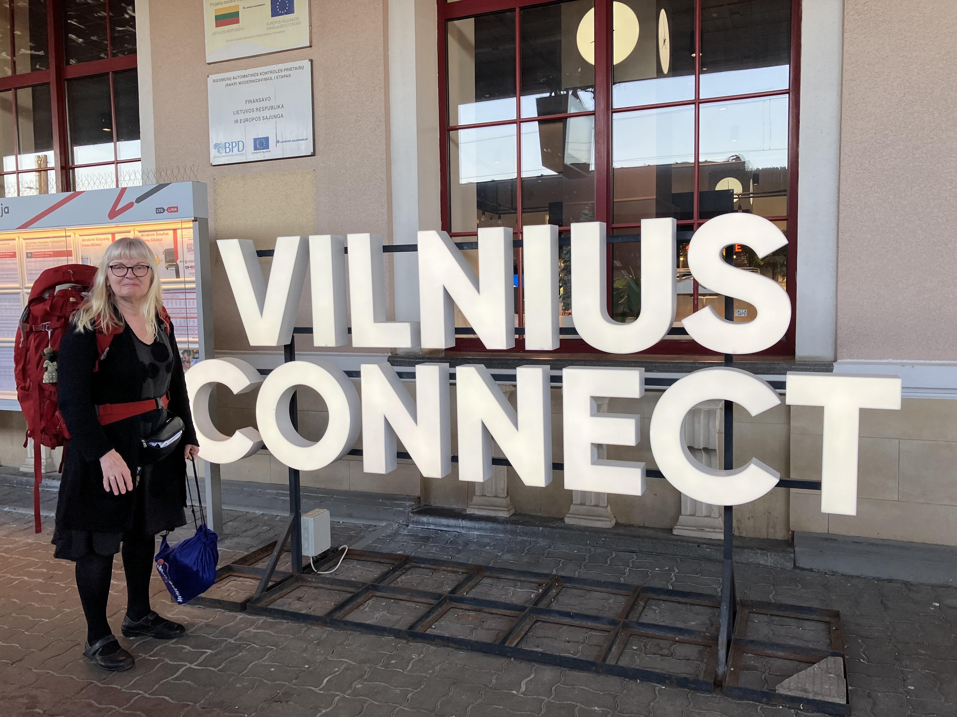 Irmeli seisoo Vilnius Connect -kirjainten vieressä