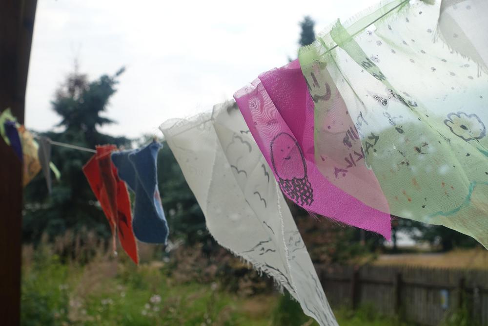 Lapsiryhmä on asettunut vaalean keskikokoisen koiran ympärille silittämään sitä. Rauhallinen koira nuuhkii lapsen kättä.