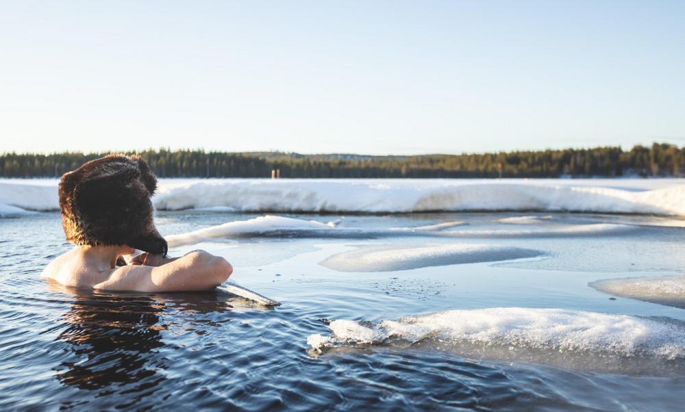 Henkilö avannossa karvalakki päässään.