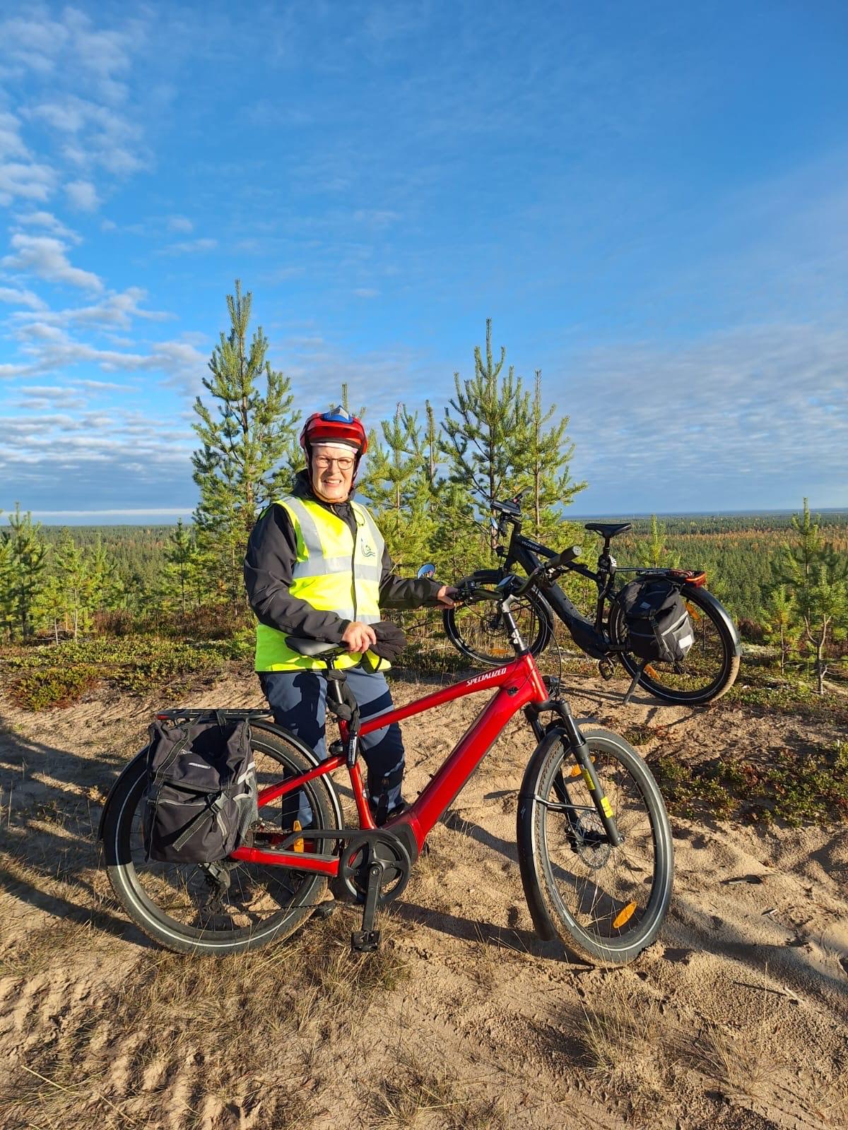 Puheenjohtaja Jaana Korhonen Mansikkaniemen laavulla oranssissa ulkoilutakissaan.