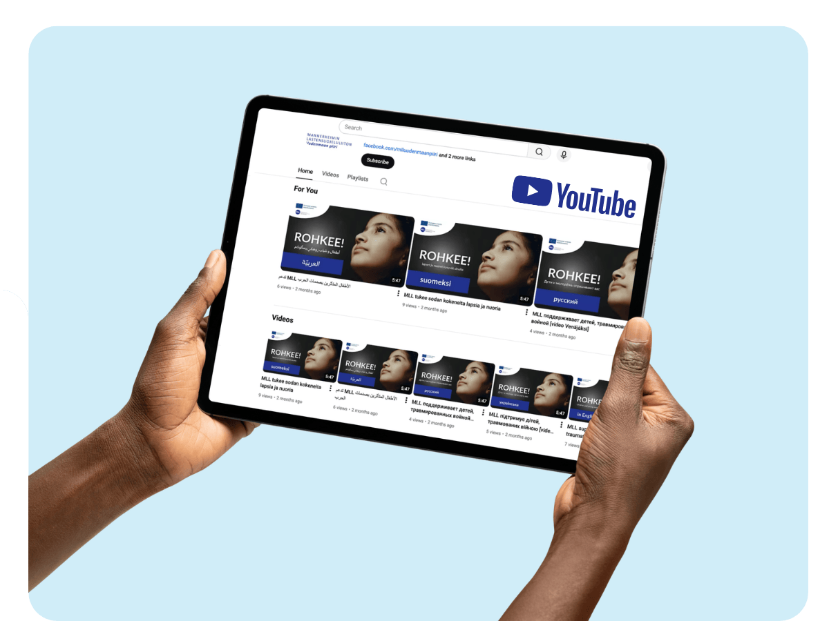 Ihminen pitää käsissään tablettia ja katselle MLL Uusimaan ROHKEE!-videoita