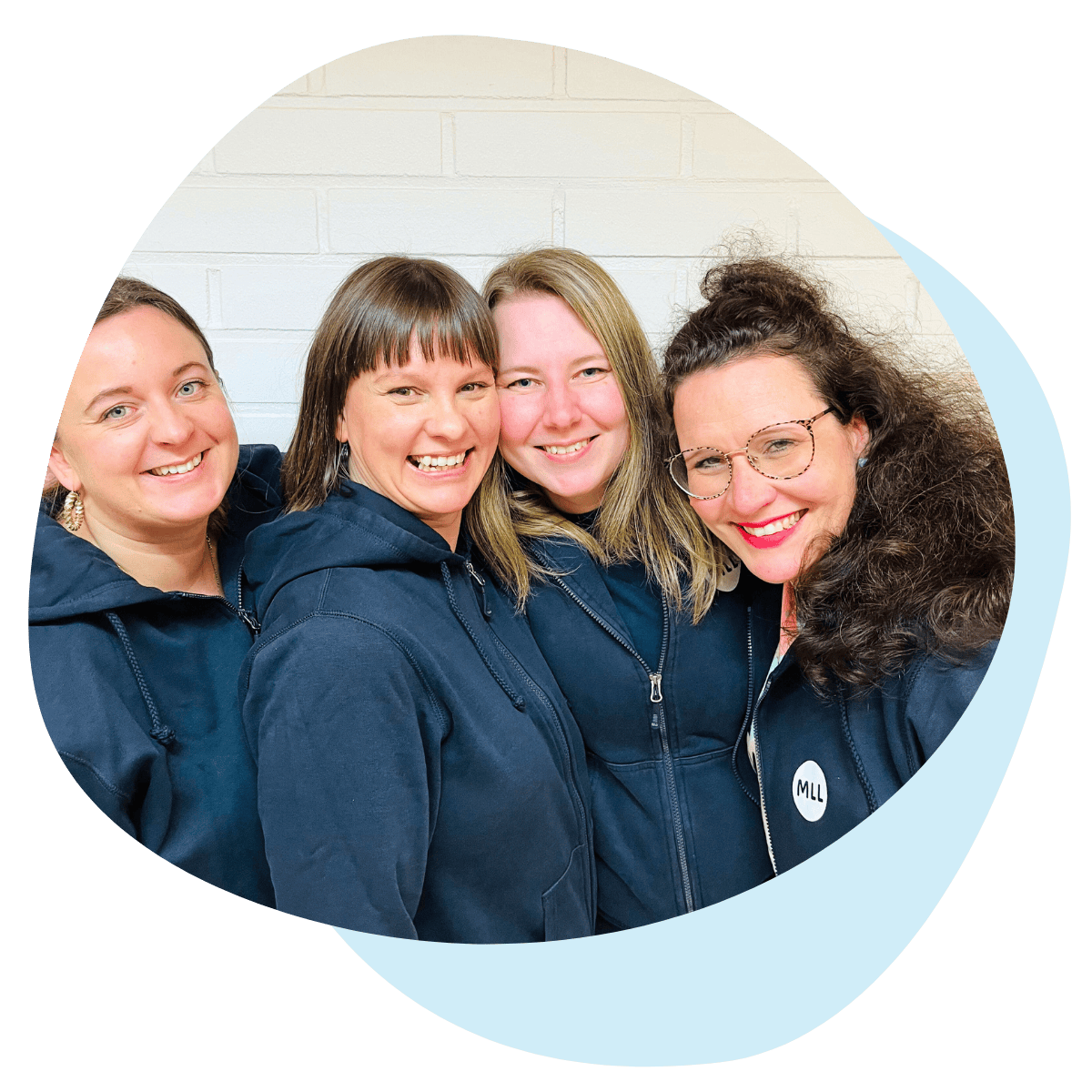 MLL Uusimaan Ehjäksi-toiminnan tiimi hymyilee ja halaa toisiaan