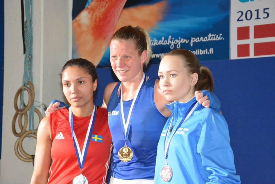 Naiset seisovat palkintokorokkeella, keskellä Mira Potkonen.