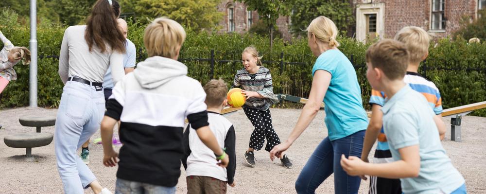 Kuvassa lapset leikkimässä pihalla polttopalloa