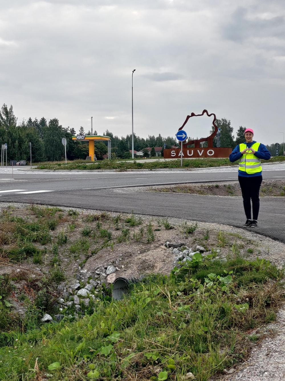 Elisa Rinne MLL:n huomioliivi päällä näyttämässä käsillään sydäntä.