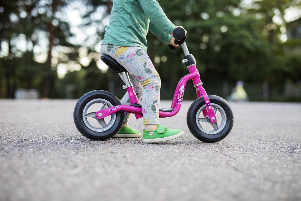 Kuvituskuva, lapsi potkupyörällä. 