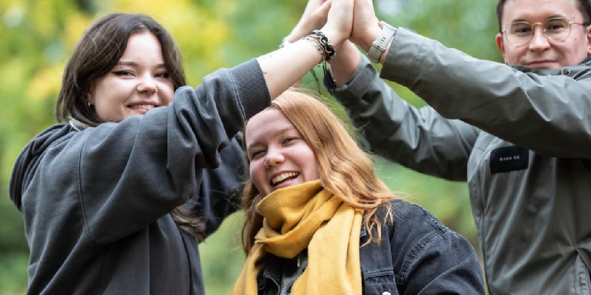 Kuvassa kolme iloista ja hymyilevää nuorta Oulun 4H:n toiminnassa.