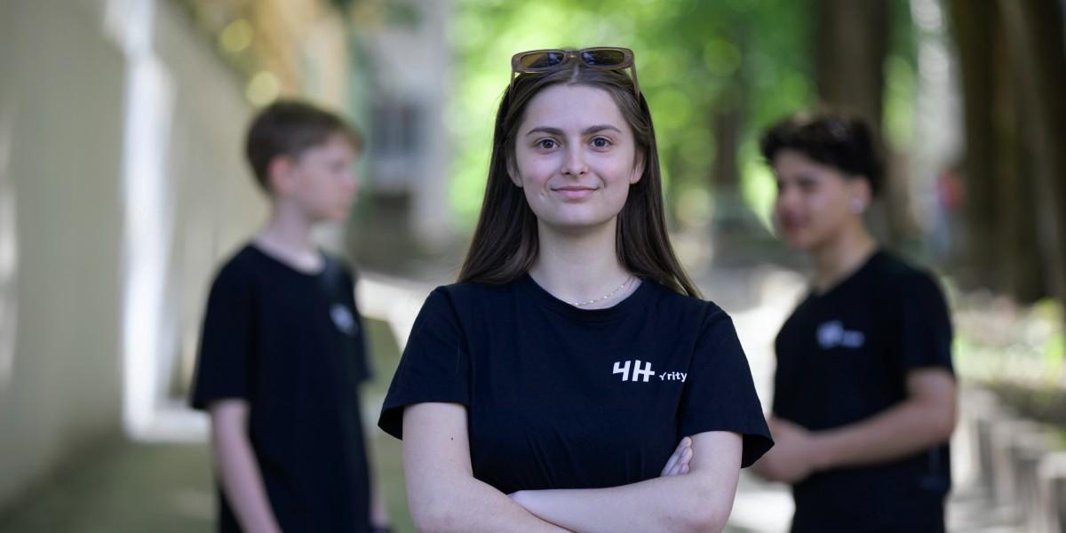 Etualalla on hymyilevä nuori 4H-yrittäjä ja hänen takana kaksi nuorta lisää keskustelemassa yrittäjyydestä Oulussa.