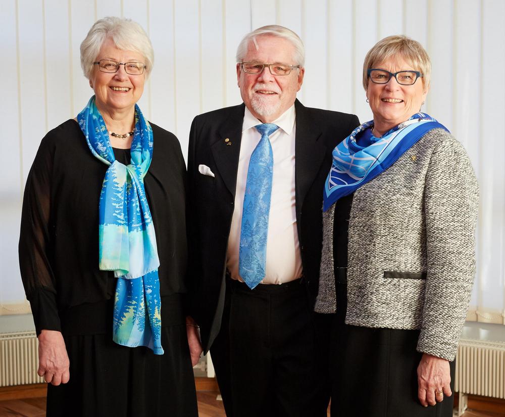 Kolme senioria juhlavaatteissa poseeraamassa