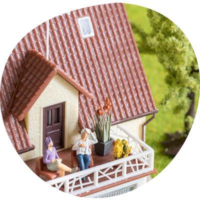 Kuvituskuva jossa näkyy omakotitalon yläkerran parveke ja parvekkeella kaksi ihmistä istumassa.