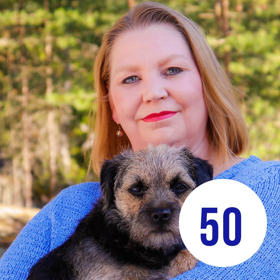 Kuvassa Maria koira sylissä