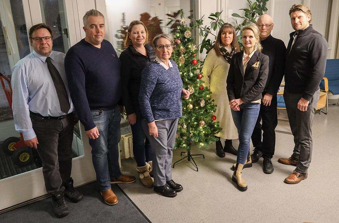 Ryhmäkuvassa yhdistyksen hallituksen jäsenet kuvan oton aikaan sopivasti koristellun joulukuusen ympärillä