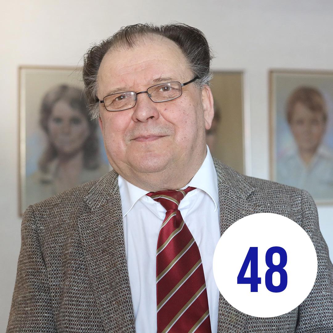 Kuvassa Heikki sisällä taulut taustalla