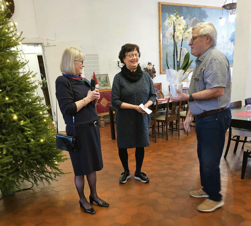 Varkauden seudun seniorien edustajat Katriina ja Päivi ojentavat KaksRuusun isännälle Pekka Kinnuselle kukat.