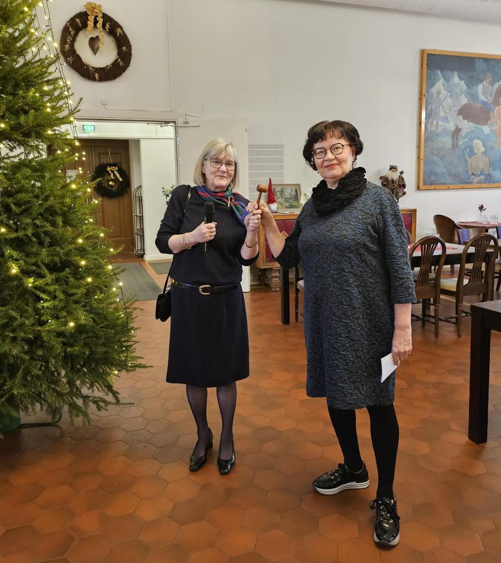 Uusi puheenjohtaja Päivi Ketola vastaanottaa Katriina Niemiseltä puheenjohtajan nuijan.