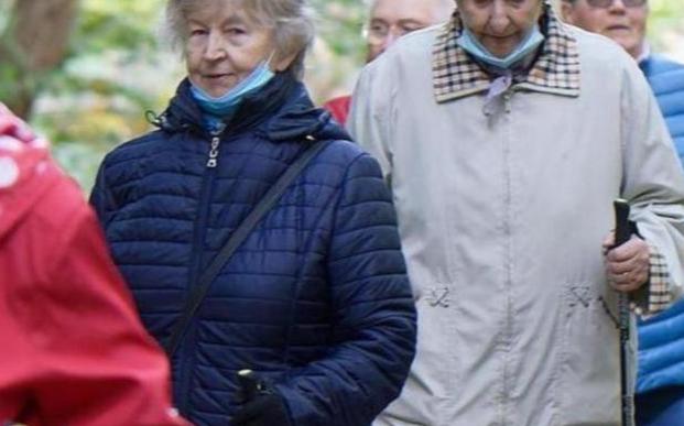 Kynttilä palaa lyhdyssä, lyhdyn ympärillä jouluinen kranssi.
Kuva Pixabay.