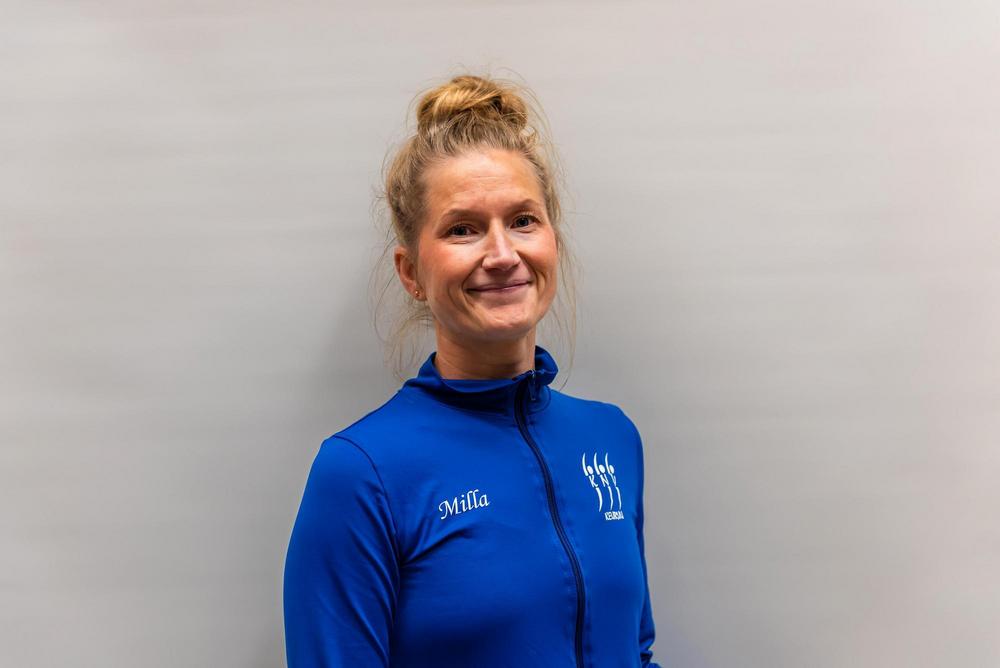 Milla Nybacka poseeraa sinisessä takissa.