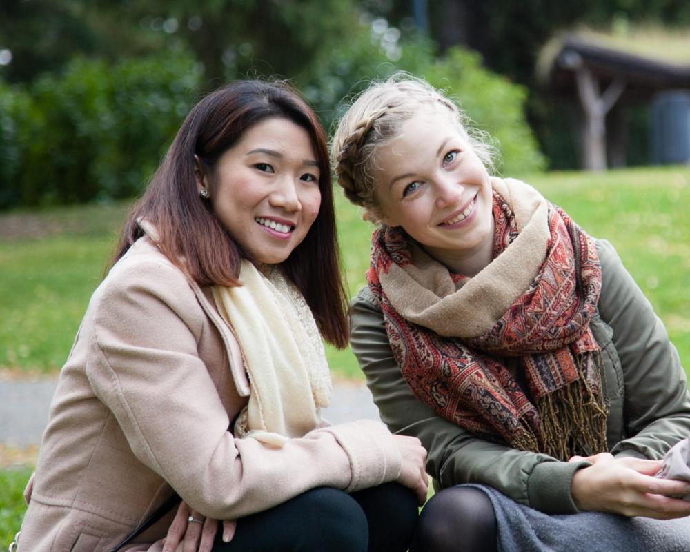 Valokuva: Kaksi nuorta naista hymyilevät.
