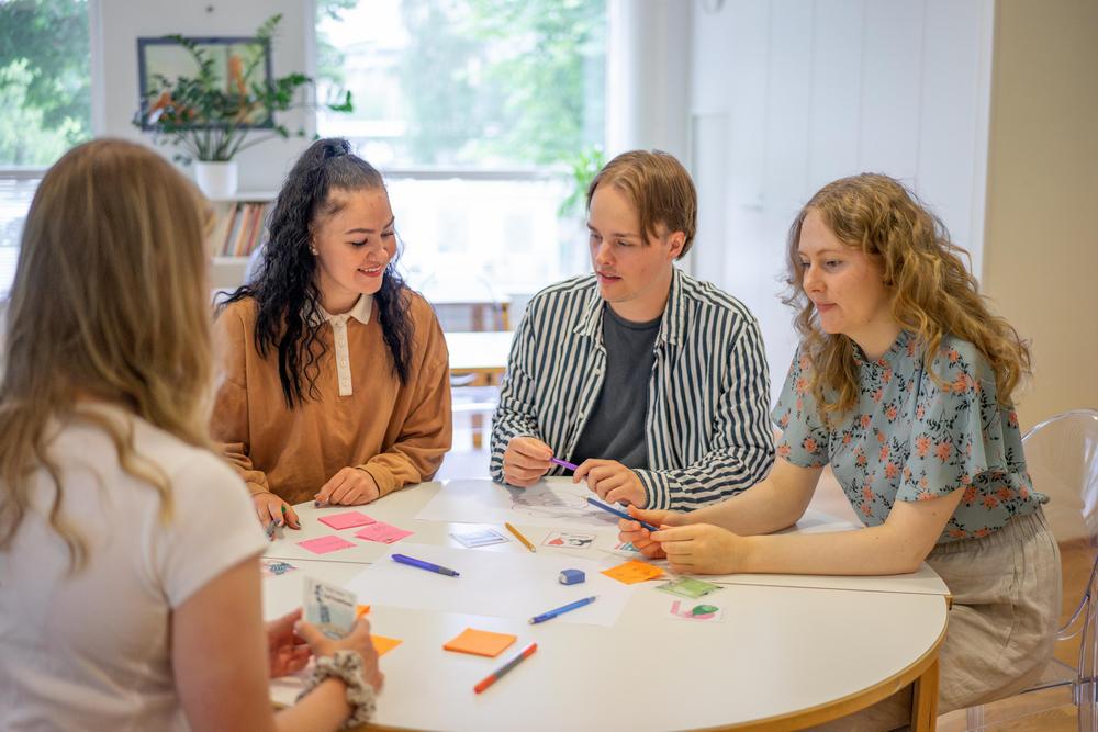 Valokuva: Joukko nuoria istuu piirissä.