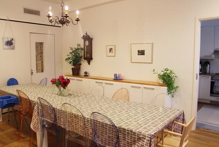 Valokuva: Kuvassa Laivapuiston perhetalon salin ruokailutila. Kuvassa pitkä ruokapöytä tuoleineen.