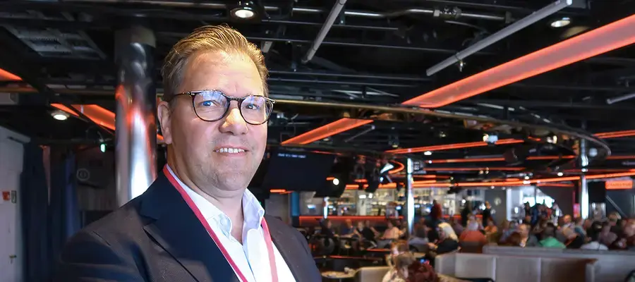 Jarkko Järvitalo hymyilemässä taustallaan risteilylaivan kokoustilat.