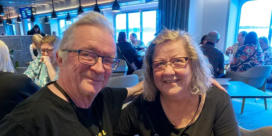 Marja-Leena Wulff ja Erkki Poikolainen hymyilevät rinnakkain laivan seminaaritilassa otetussa kuvassa.