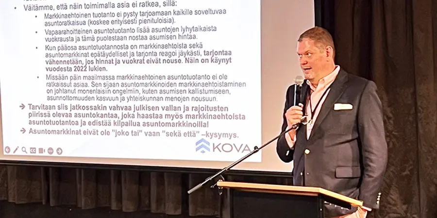 KOVA ry:n toimitusjohtaja Jouni Parkkonen lavalla mikrofoni kädessään.