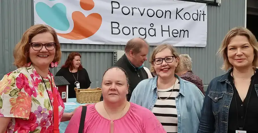 Marjut Sandsjoe, Heidi Liljemark, Mariella Koskinen ja Laura Kalakoski hymyilemässä ulkojuhlissa taustallaan teksti "Porvoon Kodit, Borgå Hem".