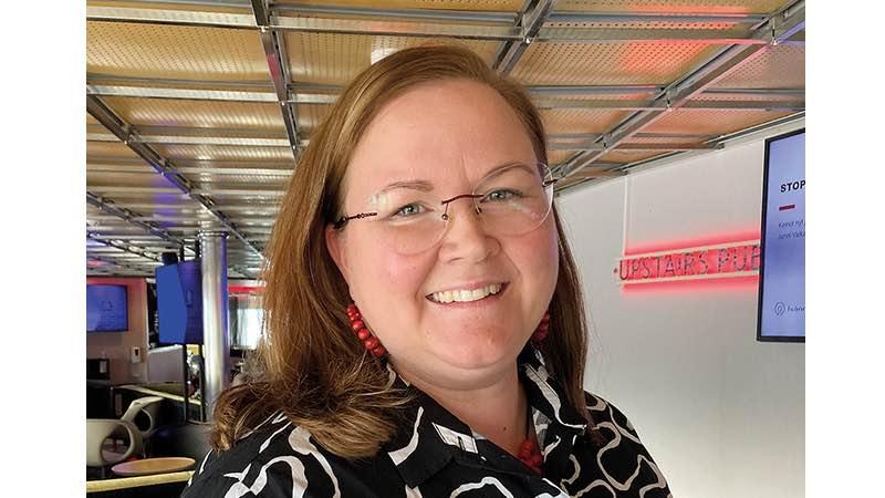 Isännöintiliiton johtava lakiasiantuntija Jenni Valkama hymyilemässä korvissaan punaiset helmikorvakorut ja päällään tumma kauluspaita. 