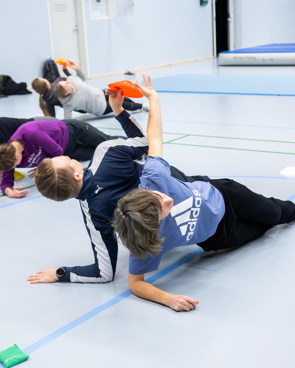 Mies ja nainen ovat kylkiseisonnassa selät vastakkain ja vaihtavat esinettä ilmassa kädestä käteen. Kuva Essi Kultanen.