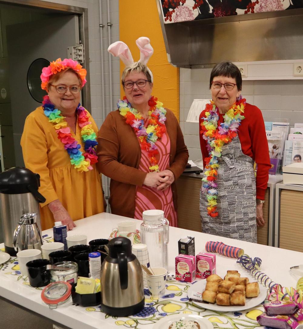 Näkymä Onnensillan kahviosta, jossa on runsaasti eri-ikäisiä henkilöitä juomassa kahvia, juttelemassa ja lukemassa päivän lehtiä.