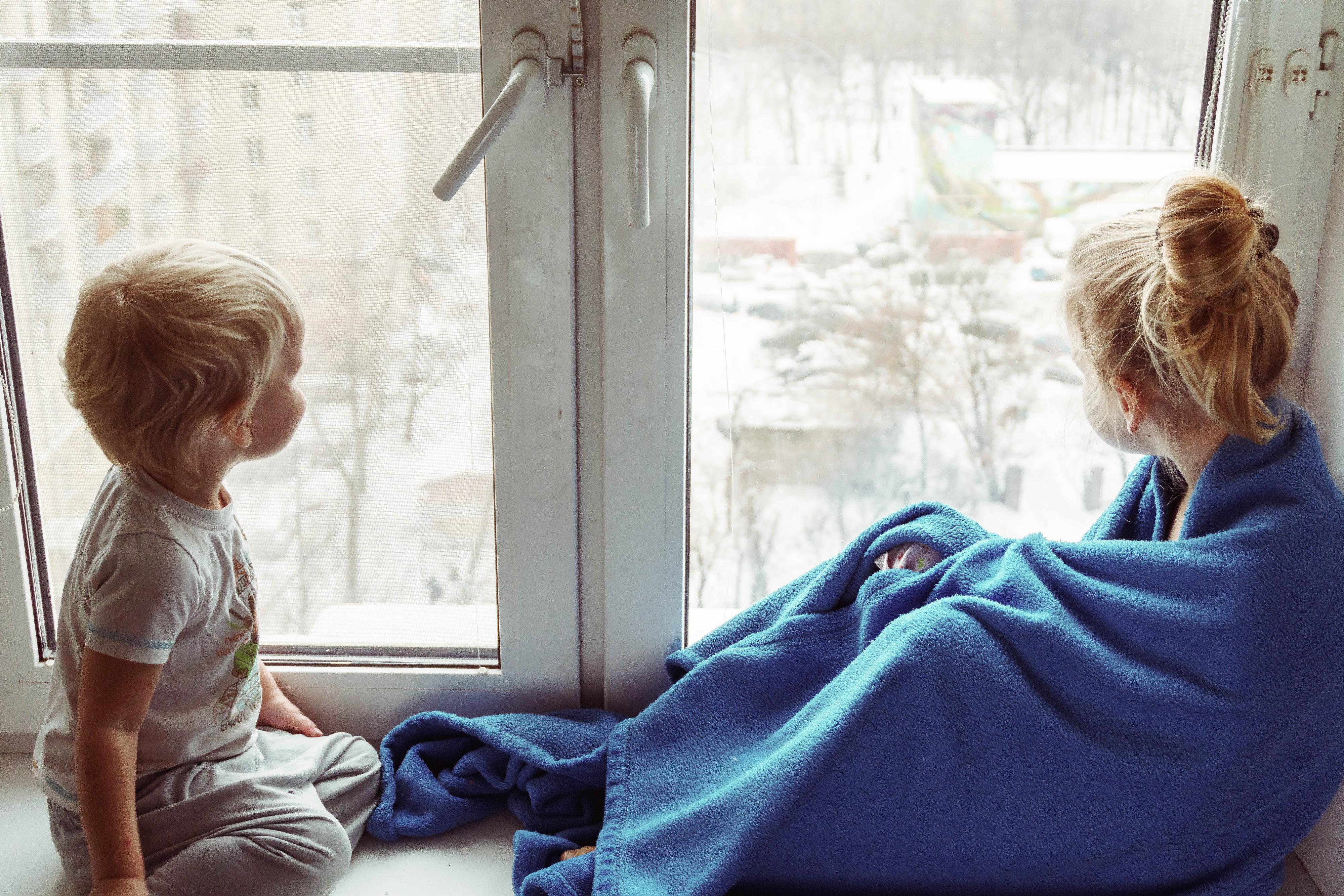 Lapset istuvat ikkunalaudalla ja katselevat ulos.