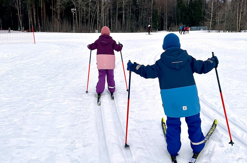 Kaksi lasta hiihtämässä Pienperheyhdistyksen järjestämässä toiminnassa.