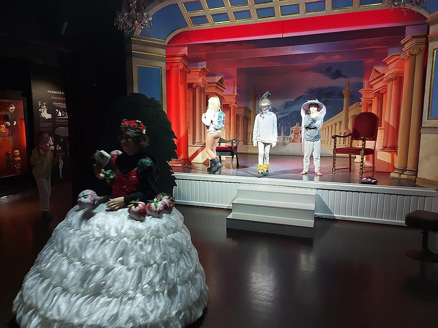 Teatteri, jonka lavalla on kolme hahmoa. 