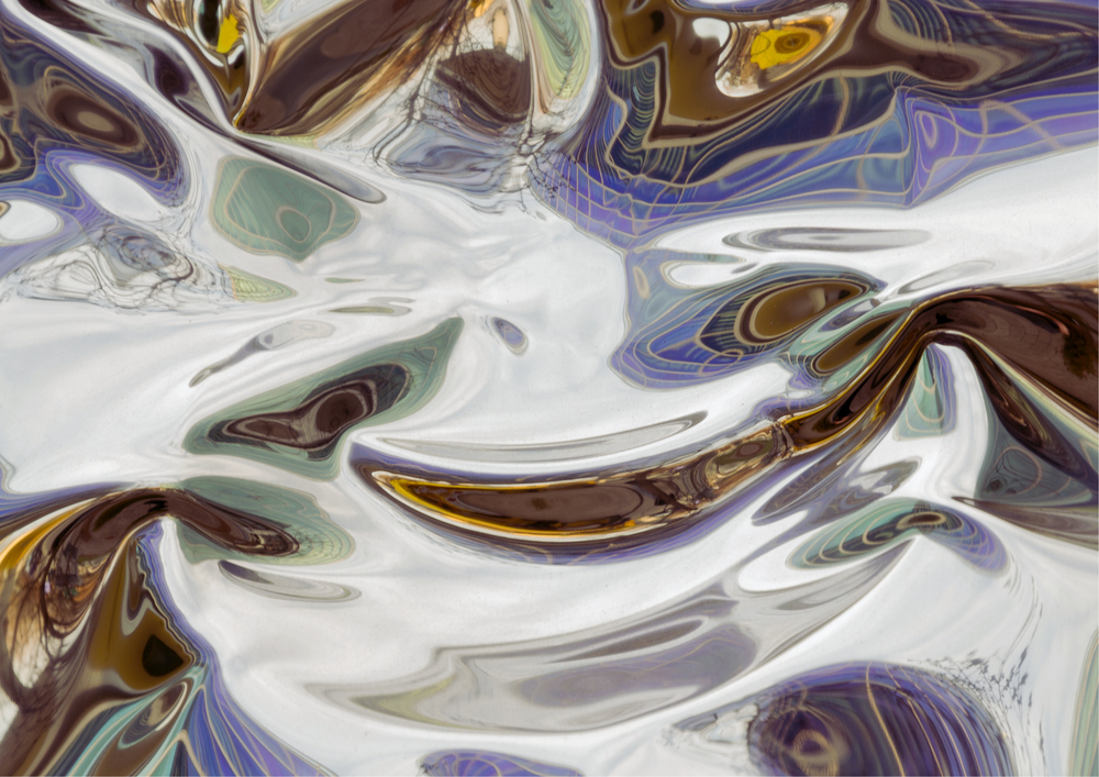 Kuvassa epäselvä heijastuma veden pinnassa uima-altaan sinisistä kaakeleista ja taivaasta.