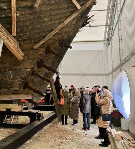 Yli 24 metriä pitkä hylky on osoittautunut yhdeksi Euroopan kaikkien aikojen suurimmista keskiaikaisista laivalöydöistä. Pääsimme katsomaan sitä teltassa, missä sitä parhaillaan restauroidaan. 