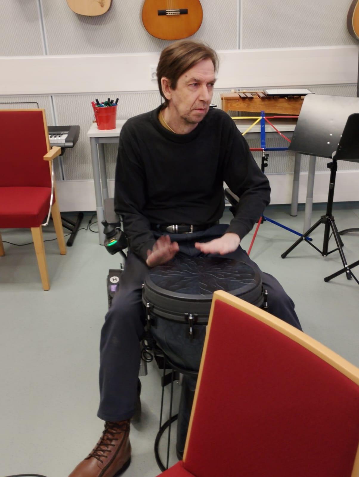 Istuva mies soittaa bongorumpuja.