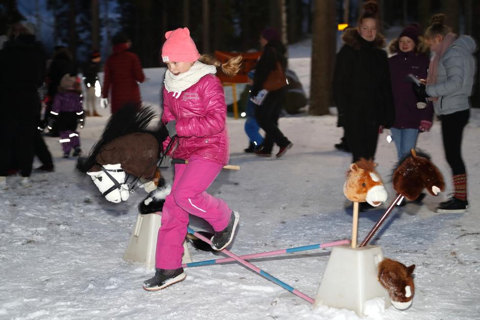 Tyttö hyppimässä keppihevosella.