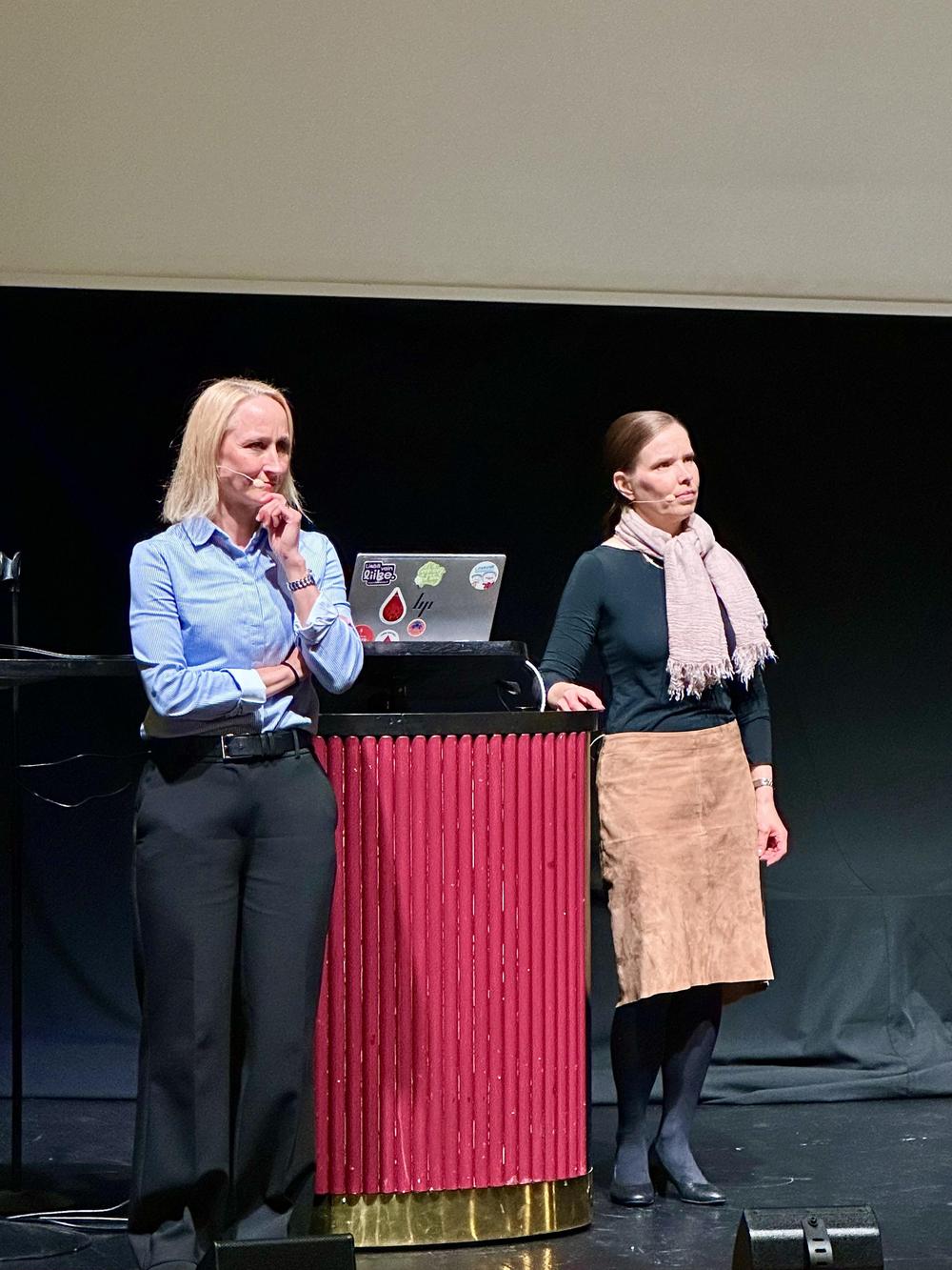 Kaksi naista pitää puheenvuoroa seminaarissa.