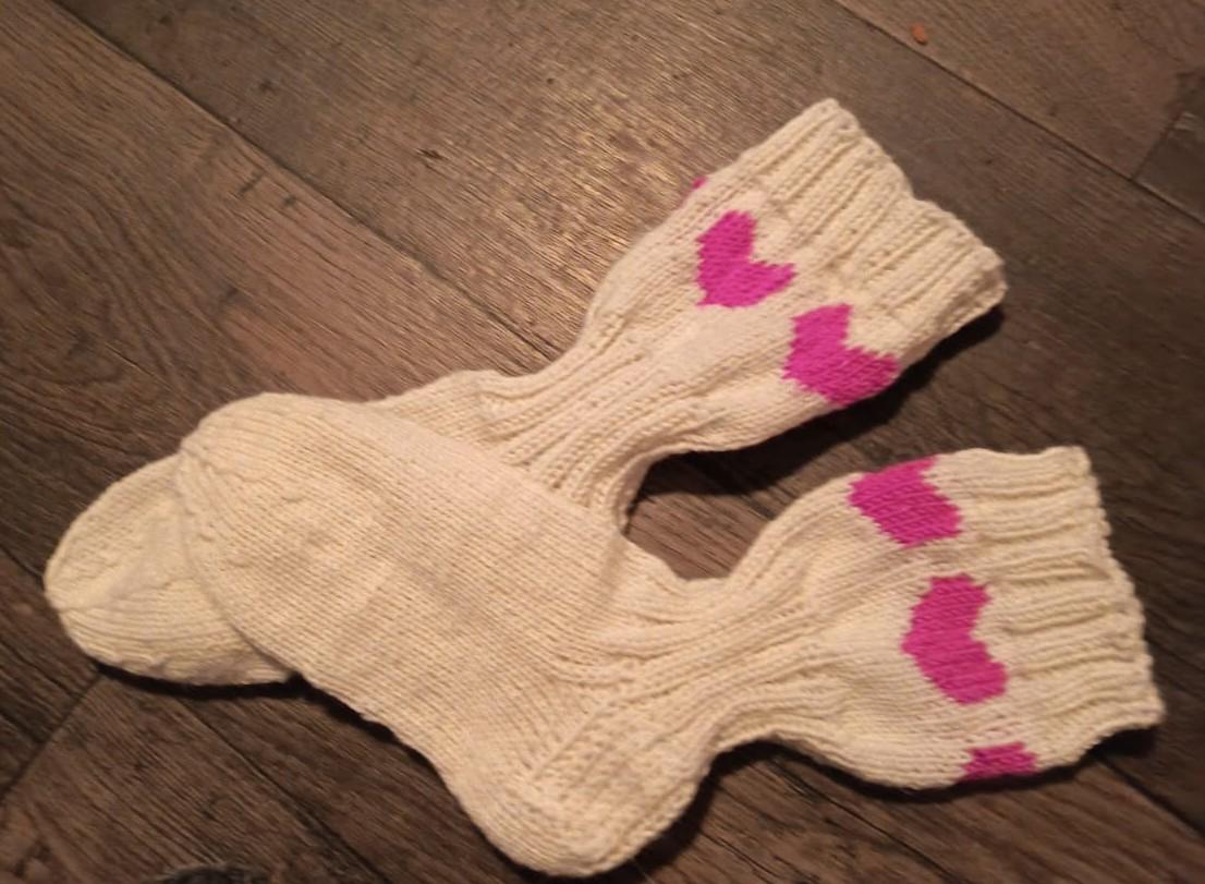 Sini-valkoiset villasukat ja sukkapuikot.