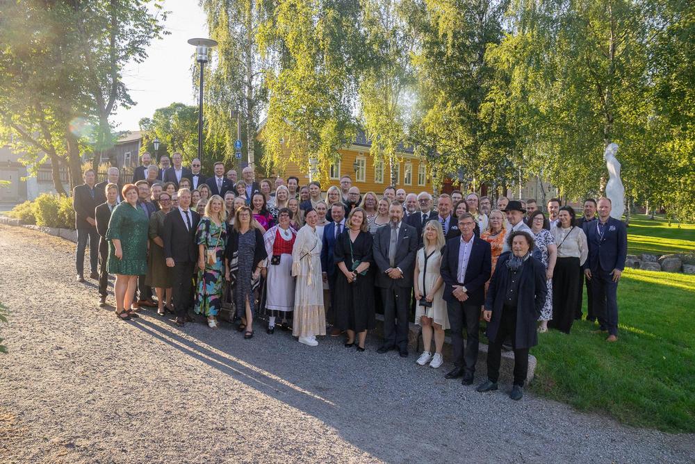 Ryhmäkuva kesäisessä puistossa.