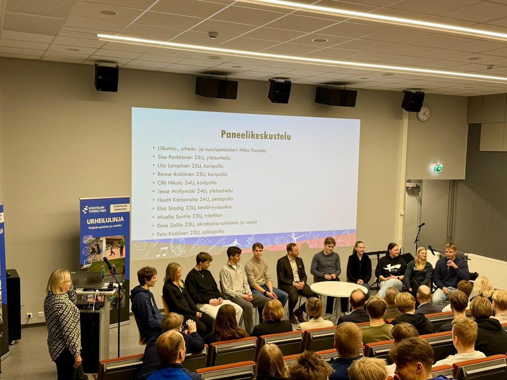 Ministeri lukiolla paneelikeskustelussa nuorten kanssa puolikaaressa auditoriossa