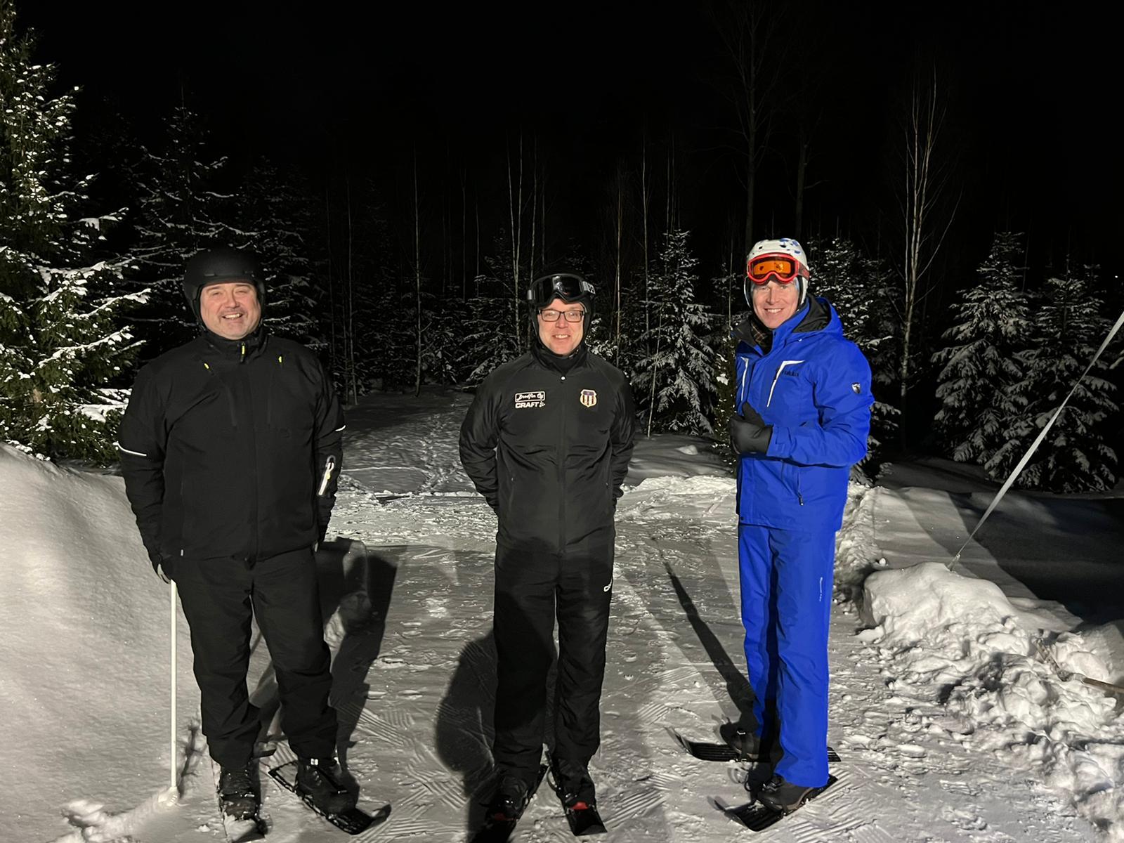 Jari Liikkanen, Tommi Lehtinen ja Antti Blom seisovat kasvot kameraan pienen pihaan tehdyn lumihyppyrin vierellä pienet minisukset, eli liparit jalassa