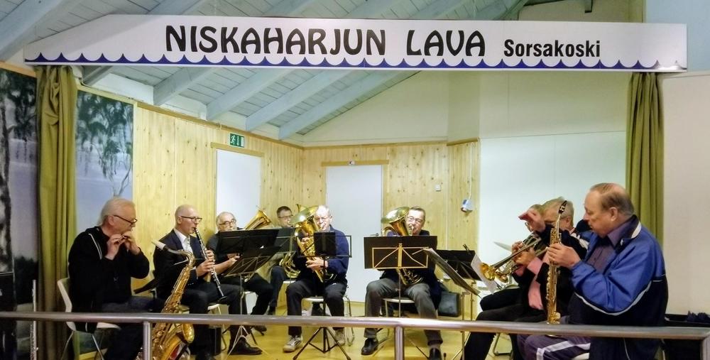 lavalla esiintymässä miesporukka joilla eri soittimia