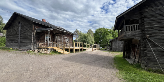 Useita perinteisiä hirsirakennuksia pihapiirissä.