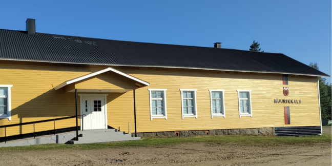 Keltainen puutalo, jonka kyljessä lukee "Muurikkala".