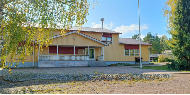 Vilniemen kylätalo. Suuri keltainen puutalo kesäisessä maisemassa.