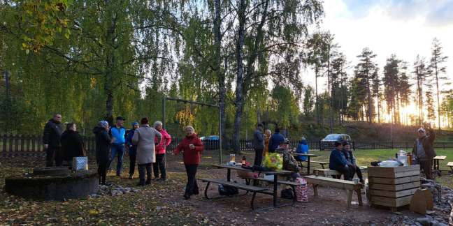 Kesäinen ilta, jossa ihmisiä yhdessä grillaamassa.